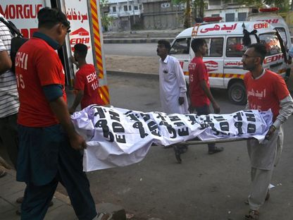 متطوعون ينقلون جثامين ضحايا الحادث المروري الذي أودى بحياة 17 شخصاً على الأقل. كراتشي، باكستان. 11 أبريل 2024 - AFP