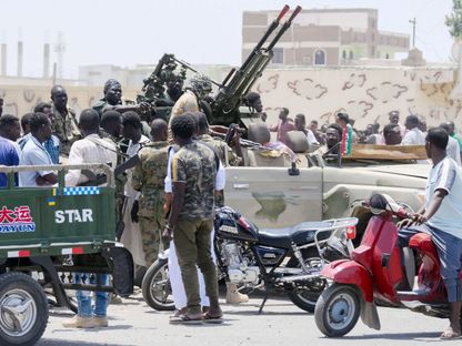 سودانيون يحيون جنود الجيش في مدينة بورتسودان المطلة على البحر الأحمر . 16 أبريل 2023 - AFP