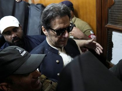 ضباط أمن يرافقون رئيس الوزراء الباكستاني السابق عمران خان أثناء مثوله أمام المحكمة العليا في لاهور. 19 مايو 2023 - REUTERS