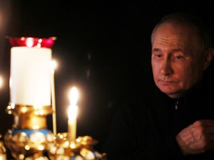الرئيس الروسي فلاديمير بوتين يضيء شمعة حداداً على أرواح ضحايا هجوم موسكو خلال زيارته لكنيسة في نوفو-أوجاريوفو قرب موسكو. 24 مارس 2024 - AFP
