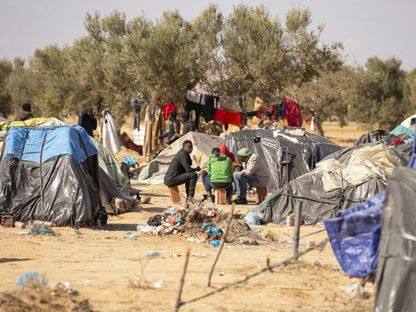 مهاجرون أفارقة ينصبون خياماً عقب وصولهم إلى تونس ضمن رحلتهم للجهرة إلى أوروبا في صفاقس بتونس. 31 يناير 2024 - AFP