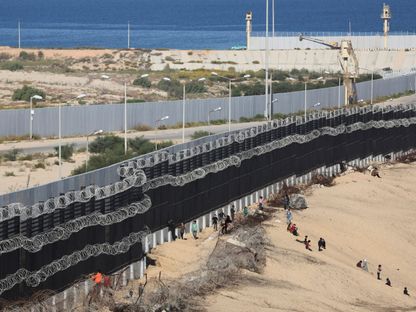 نازحون فلسطينيون فروا من منازلهم بسبب الضربات الإسرائيلية يتجمعون في رفح بالقرب من الجدار الحدودي مع مصر. 7 يناير 2024 - Reuters