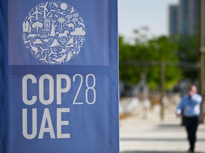 أشخاص يسيرون أمام شعار COP 28 قبل انطلاق مؤتمر الأمم المتحدة المعني بتغير المناخ في دبي، بدولة الإمارات. 28 نوفمبر 2023 - AFP