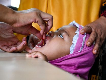طفل صغير يتلقى أحد الفيتامينات خلال فحص طبي روتيني في أحد مناطق إندونيسيا. 2 أغسطس 2022 - AFP
