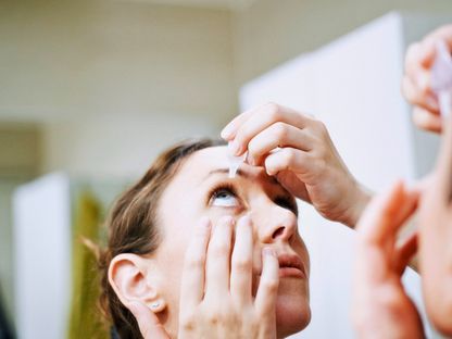 امرأة تستخدم قطرة لعلاج جفاف العين. 12 نوفمبر 2014 - AFP