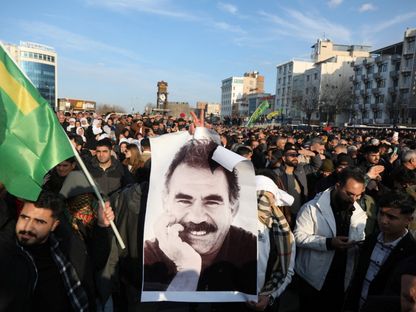 متظاهر يحمل صورة زعيم حزب العمال الكردستاني عبد الله أوجلان خلال تجمع في مدينة ديار بكر التركية. 27 فبراير 2025 - REUTERS