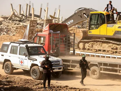 مقاتلون من حركة "حماس" يرافقون أعضاء الصليب الأحمر نحو منطقة داخل ما يسمى "الخط الأصفر في مدينة غزة. 20 نوفمبر 2025 - Reuters