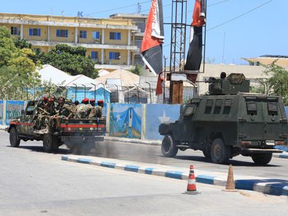 شاحنة تقل جنوداً ومركبة مصفحة تمران بالقرب من فندق استهدفته حركة الشباب وسط العاصمة الصومالية مقديشو. 15 مارس 2024 - AFP