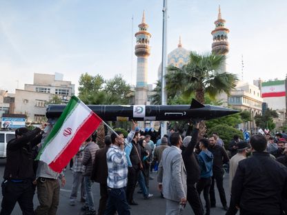 مواطنون يحملون نموذجاً لأول صاروخ إيراني تفوق سرعته سرعة الصوت، "فتاح"، خلال تجمع للاحتفال بالهجوم على إسرائيل، طهران، إيران، 15 أبريل 2024 - Afp