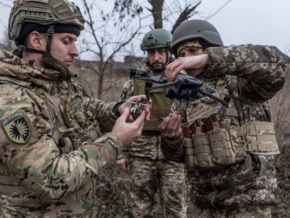 جنود أوكرانيون يقومون بتحميل قنبلة يدوية على طائرة بدون طيار خلال التداريب في دونيتسك بأوكرانيا. 25 نوفمبر 2023 - AFP