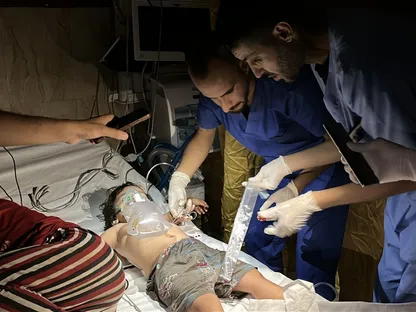 أطباء يحاولون إسعاف طفل فلسطيني أصيب في غارة إسرائيلية باستخدام أضواء الهاتف بعد انقطاع الكهرباء عن مستشفى الأقصى في دير البلح. 7 يوليو 2025 - Reuters