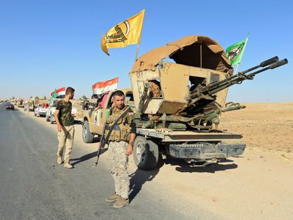 مقاتل من قوات الحشد الشعبي العراقية يقف بجوار آلية عسكرية خلال العمليات ضد تنظيم 'داعش' في زمار بمحافظة نينوى. 18 أكتوبر 2017 - Reuters