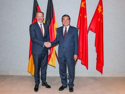 وزير المالية الألماني كريستيان ليندنر يصافح نائب رئيس مجلس الدولة الصيني هي ليفنج في فرانكفورت. 1 أكتوبر 2023 - AFP