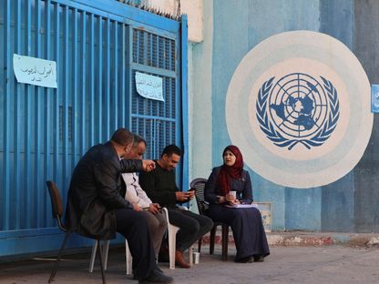 معلمون فلسطينيون يجلسون أمام المقر الرئيسي لوكالة غوث وتشغيل اللاجئين "أونروا" في غزة أثناء إضراب عام لموظفي الوكالة في القطاع – 29 نوفمبر 2021 - AFP