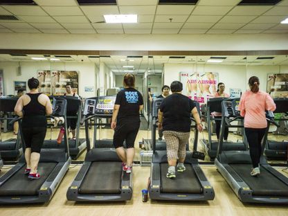 أشخاص يعانون من زيادة الوزن يتلقون علاجاً رياضياً في مستشفى في الصين للحد من الدهون في 25-5-2015. - AFP