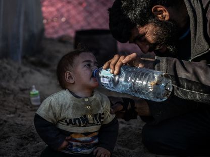 طفل فلسطيني يشرب الماء وسط كفاح النازحين من أجل العثور على مياه نظيفة في رفح، جنوب قطاع غزة. 9 فبراير 2024 - AFP