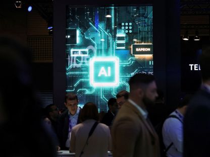 أشخاص يسيرون بالقرب من لافتة تحمل شعار  الذكاء الاصطناعي (AI) في المؤتمر العالمي للهواتف في برشلونة بإسبانيا. 27 فبراير 2024 - Reuters