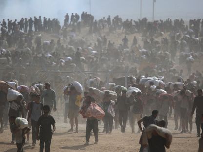 فلسطينيون يحملون مساعدات إغاثية وسط أزمة جوع متفاقمة، وسط غزة، 4 أغسطس 2025 - REUTERS