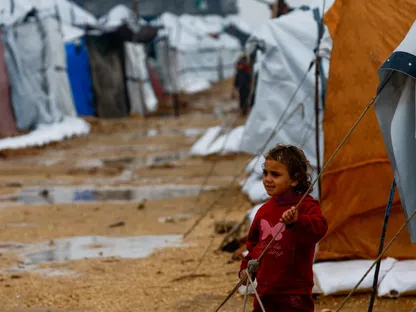 طفلة فلسطينية نازحة في مخيم خلال يوم ممطر في النصيرات وسط قطاع غزة. 11 ديسمبر 2025 - Reuters