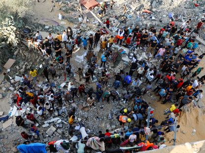 فلسطينيون يبحثون عن أحياء عالقين تحت أنقاض مبنى دمرته غارة إسرائيلية في خان يونس جنوبي قطاع غزة. 16 أكتوبر 2023 - Reuters