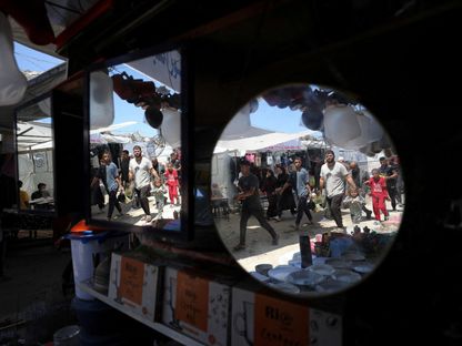 فلسطينيون يتسوقون في سوق بالقرب من أنقاض المنازل في مخيم جباليا للاجئين، شمال قطاع غزة. 8 مايو 2025 - Reuters
