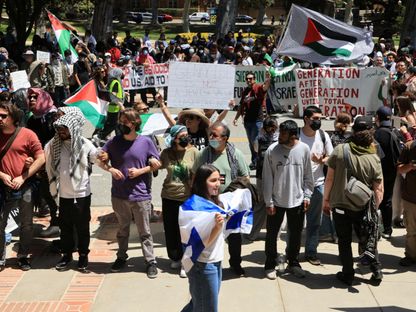 مؤيدة لإسرائيل تمر قرب تظاهرة ضد الحرب على قطاع غزة بجامعة كاليفورنيا في لوس أنجلوس بولاية كاليفورنيا. 28 أبريل 2024 - REUTERS