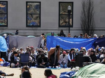 مجموعة من الطلاب تغطي المنطقة التي تجمع فيها آخرون للصلاة أثناء مشاركتهم في معسكر احتجاج طلابي لدعم الفلسطينيين في حرم جامعة كولومبيا في مدينة نيويورك، الولايات المتحدة. 26 أبريل 2024 - Reuters
