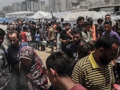فلسطينيون يصطفون أمام أحد مراكز توزيع المساعدات الغذائية في شمال قطاع غزة. 27 مايو 2025 - Bloomberg