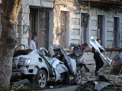 سكان يزيلون الأنقاض من مبنى شققهم الذي تضرر جراء غارة بطائرة مسيرة روسية، وسط هجوم روسيا على أوكرانيا، في أوديسا، أوكرانيا. 10 يونيو 2025 - Reuters