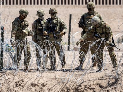 قوات الحرس الوطني في ولاية تكساس تقف امام أسلاك شائكة على الحدود الأميركية المكسيكية. 11 مايو 2023 - AFP