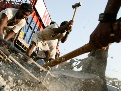 عمال هنود يقومون بشق طريق في وسط مومباي، 11 أبريل 2007- - Reuters