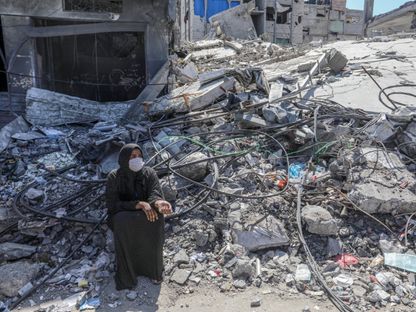 سيدة فلسطينية تجلس فوق ركام منزلها بعدما دمرته غارات إسرائيلية على مدينة رفح جنوب قطاع غزة. 6 أبريل 2024 - AFP
