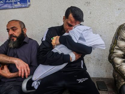 فلسطيني يحمل جثمان إحدى ابنتيه بعد قتلهما بغارة جوية إسرائيلية على مدينة رفح جنوب قطاع غزة. 4 أبريل 2024 - AFP