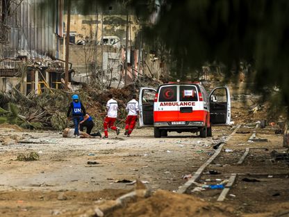 متطوعو الهلال الأحمر الفلسطيني وموظفو الأمم المتحدة يساعدون في نقل فلسطيني أصيب برصاص الاحتلال الإسرائيلي في قطاع غزة بفلسطين. 25 نوفمبر 2023 - AFP