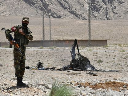 جندي من شرطة بلوشستان يقف بجانب حطام طائرة هليكوبتر. 7 يونيو 2018 - REUTERS