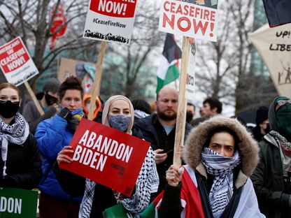 متظاهرون معارضون للحرب في غزة يقفون أمام قاعة في وارن بولاية ميشيجان خلال زيارة الرئيس الأميركي جو بايدن. 1 فبراير 2024 - Reuters