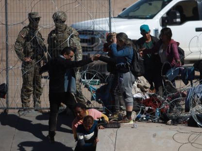 الحرس الوطني في تكساس يحتجز المهاجرين الذين يعبرون نهر ريو غراندي لطلب اللجوء الإنساني قبل عبور حدود الولايات المتحدة في سيوداد خواريز، المكسيك، 16 فبراير 2024 - AFP