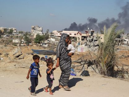 امرأة فلسطينية تنزح مع أطفالها بعدما أجبرها الجيش الإسرائيلي على إخلاء منطقة في خان يونس كانت تؤوي النازحين بجنوب قطاع غزة. 16 أغسطس 2024 - REUTERS