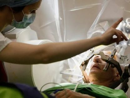جراح أعصاب يتحدث مع مريض يخضع لعملية جراحية بالدماغ في المعهد الوطني لطب الأعصاب في بودابست. 15 ديسمبر 2012 - Reuters