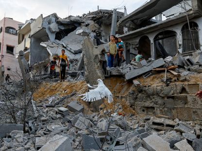 أطفال وسط أنقاض منازل دمرتها الغارات الإسرائيلية في خان يونس جنوب قطاع غزة. 11 أكتوبر 2023 - REUTERS
