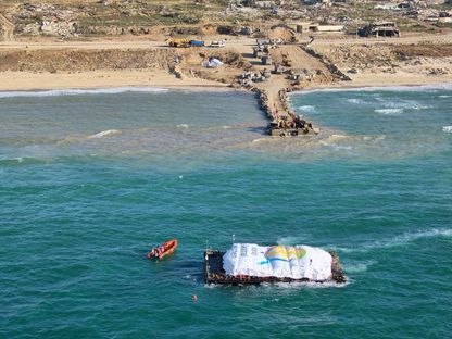 جهود إفراغ حمولة أولى سفن مساعدات الممر البحري إلى قطاع غزة. 15 مارس 2024 - Reuters
