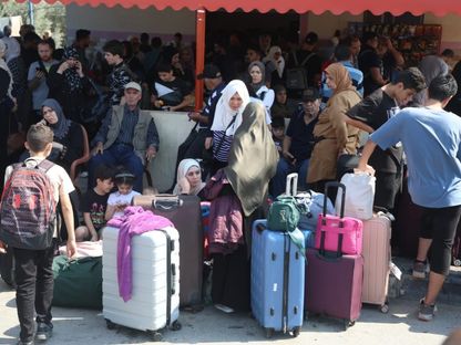 عدد من الفلسطينيين الحاملين لجنسيات أجنبية ينتظرون على الجانب الفلسطيني من معبر رفح للعبور إلى مصر مع تصاعد القصف الإسرائيلي على قطاع غزة. 14 أكتوبر 2023 - "الشرق"