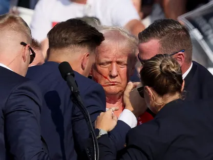 عناصر من الخدمة السرية يحيطون بالرئيس الأميركي دونالد ترمب بعد محاولة اغتياله خلال حدث انتخابي في باتلر بولاية بنسلفانيا. 13 يوليو 2024 - Reuters