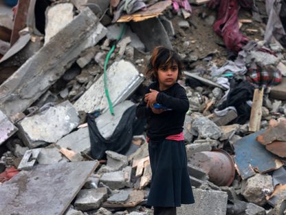 طفلة فلسطينة أمام حطام منزل دمرته غارة إسرائيلية على رفح جنوبي قطاع غزة. 24 مارس 2024 - AFP
