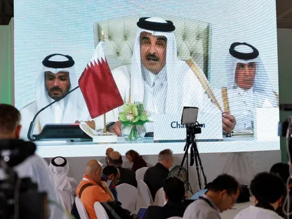 صحافيون أمام شاشة تظهر أمير قطر الشيخ تميم بن حمد خلال افتتاح القمة العربية الإسلامية الطارئة على شاشة في المركز الإعلامي بالدوحة. 15 سبتمبر 2025 - REUTERS