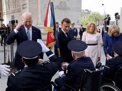 الرئيسان الفرنسي إيمانويل ماكرون والأميركي جو بايدن بجانب زوجتيهما بريجيت ماكرون (على اليمين) وجيل بايدن (الثاني على اليمين) يحييان قدامى المحاربين في الحرب العالمية الثانية خلال حفل في باريس. 8 يونيو 2024 - AFP