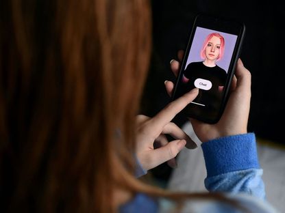 مستخدم يتفاعل مع روبوت رقمي بهيئة بشرية عبر هاتفه الذكي. 30 أبريل 2020 - AFP - AFP