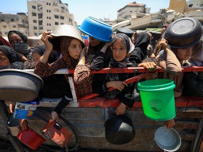 فلسطينيون يتجمعون لتلقي الطعام من مطبخ خيري، وسط أزمة جوع، في مدينة غزة، 22 يوليو 2025 - Reuters