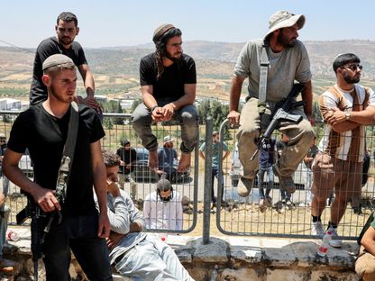 مستوطنون مسلحون في مستوطنة "إيلي" بالضفة الغربية المحتلة. 21 يونيو 2023 - Reuters