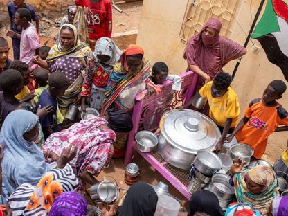 نساء سودانيات من مطابخ مجتمعية يديرها متطوعون محليون يوزعن وجبات للأشخاص المتضررين من الصراع والجوع الشديد وبعيدين عن متناول جهود المساعدة الدولية، في أم درمان، السودان. 27 يوليو، 2024 - REUTERS